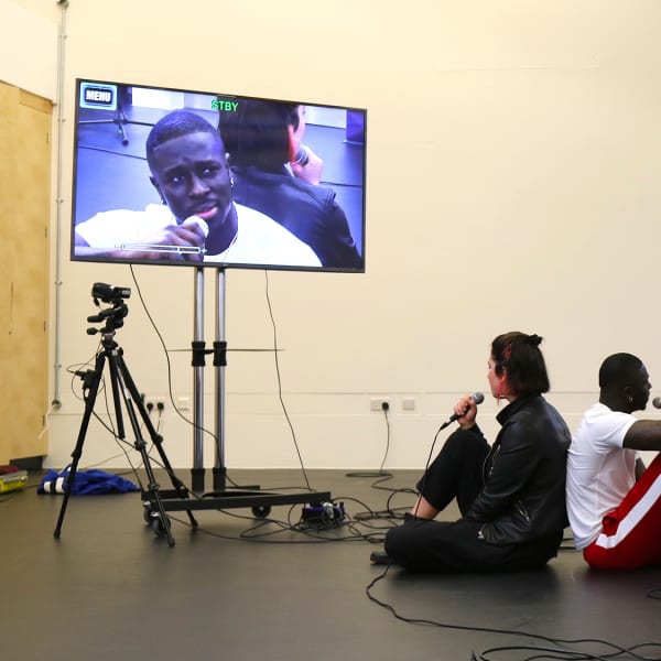 BA Contemporary Theatre and Performance students performing with microphones and 2 large screen televisions in the acting lab session.