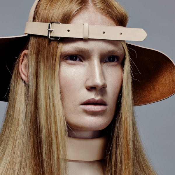 Female model in hat with glossy strawberry blonde hair.