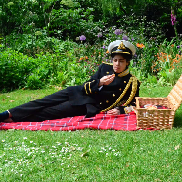 Photograph of performance in park with person in military uniform eating a picnic by Veera Rustomji - MA Fine Art.