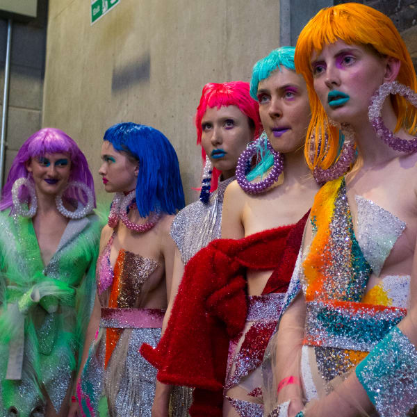 Models wearing coloured wigs and sparkly garments