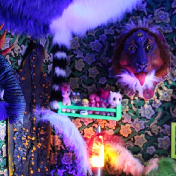 Fantastical bedroom decor full of colour, soft toys and beast-like mounted heads.