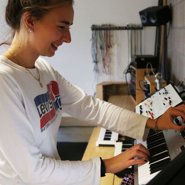 Woman playing keyboard and smiling.