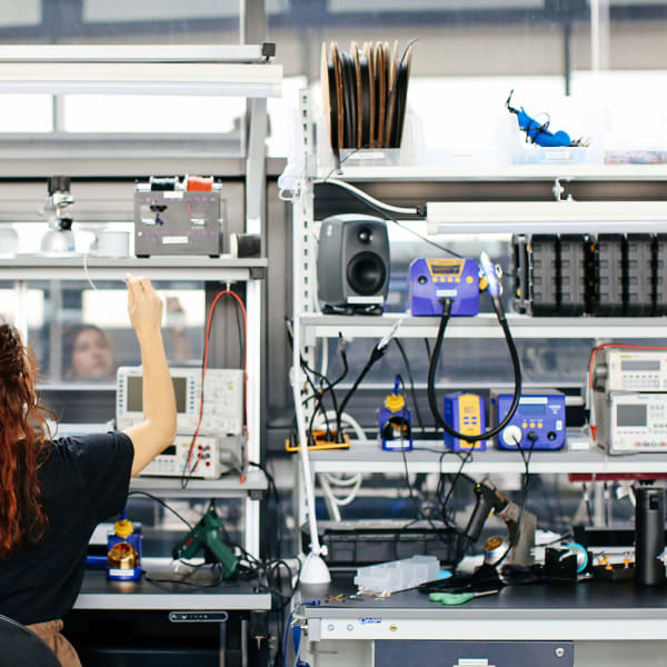 Student working in the Physical Computing Lab surrounded by lots of computational equipment
