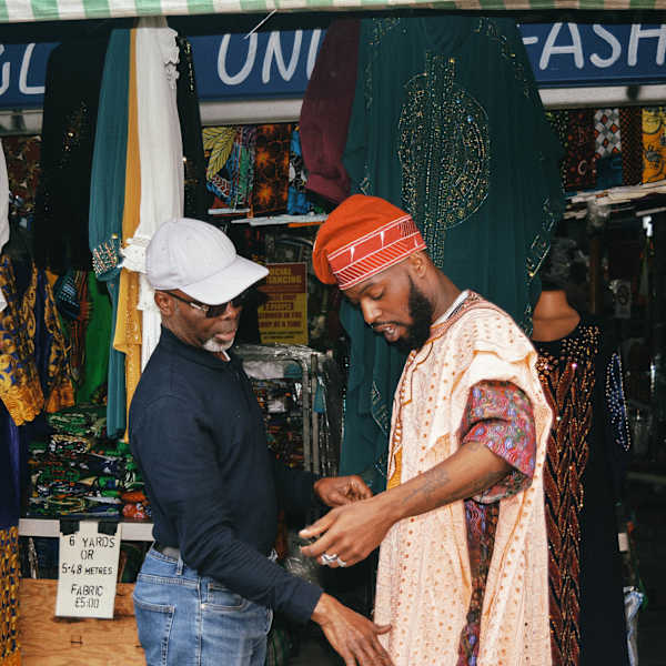 Two men at a clothing and textiles market.