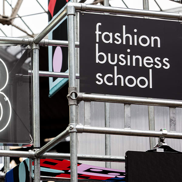 Zoomed into a letter B constructed on scaffolding with a sign that reads Fashion Business School