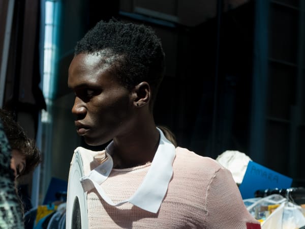 A model wearing a pink and blue knitted top and trousers 