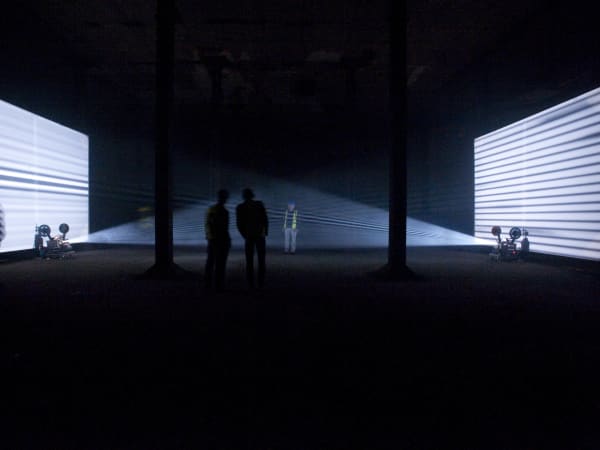 People in hi vis jackets watching a light installation