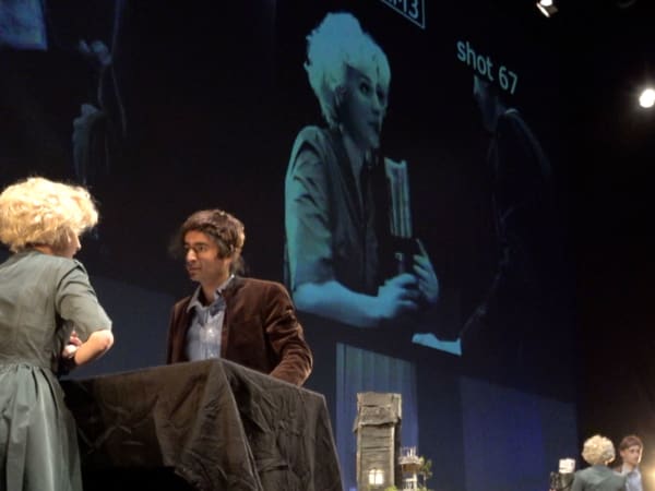 A stage performance with a large screen as backdrop