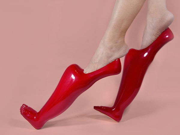 Red pointed shoes with toes on a pink background