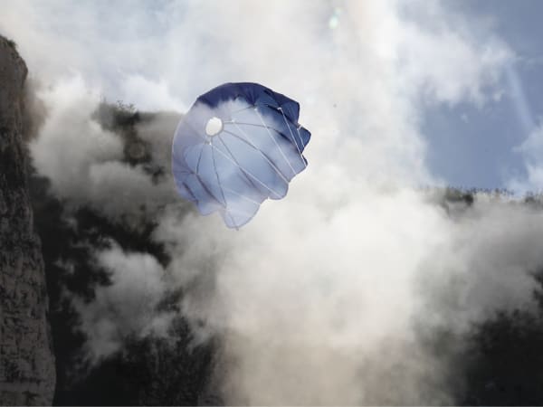 A blue parachute surrounded by clouds of mist