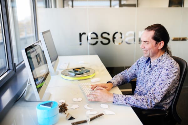 Man sitting at a desk looking at a computer.
