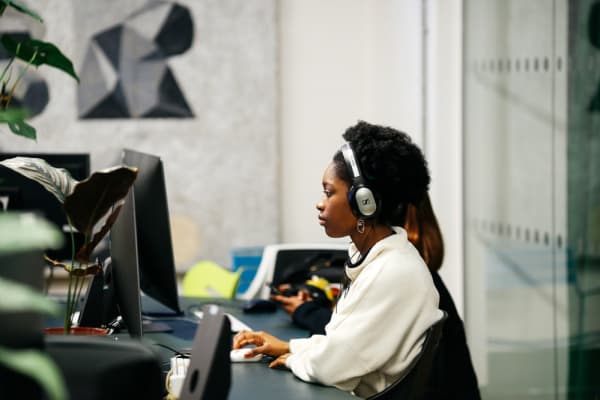 Student sat working on a computer while wearing headphones