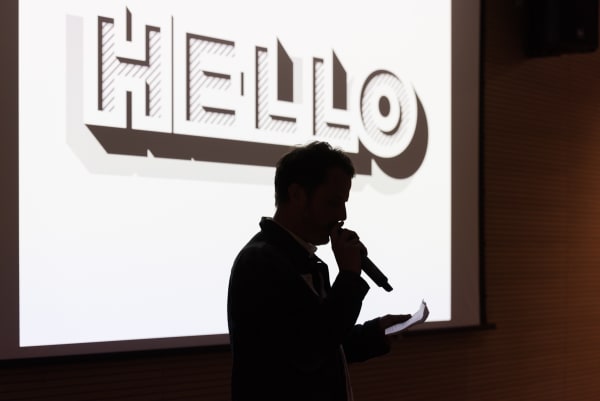 Silhouette of somebody speaking into a microphone 