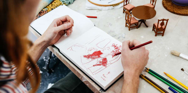 Student sketching at a table