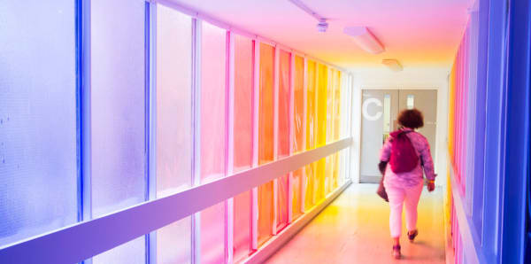 Student walking along a rainbow corridor