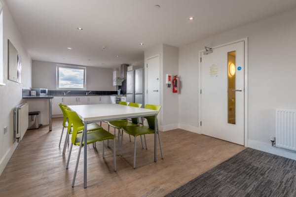 Kitchen with 2 fridge freezers, 2 sinks, 2 hobs, 2 ovens and table with 6 seats and additional sofa seating area