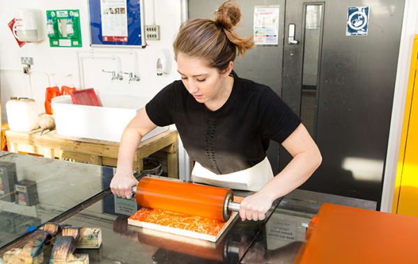 A tutor in the process of producing a print.