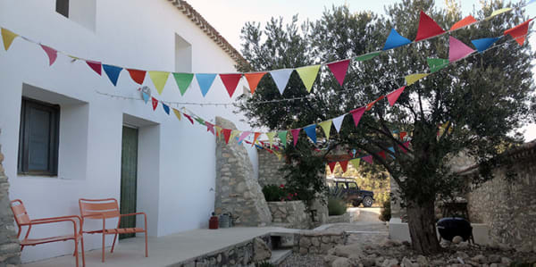 Photo of a white house with colourful bunting hanging outside 