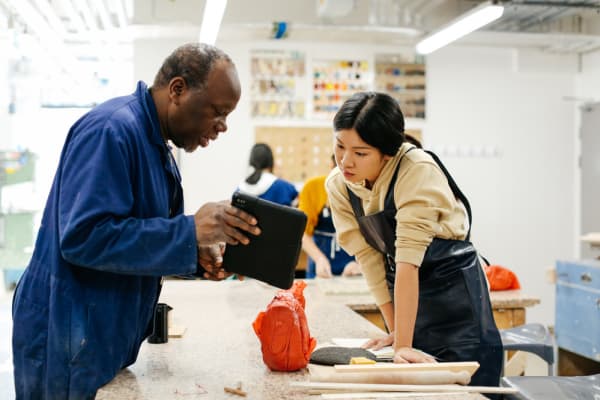 Technician and student conferring over a workbench