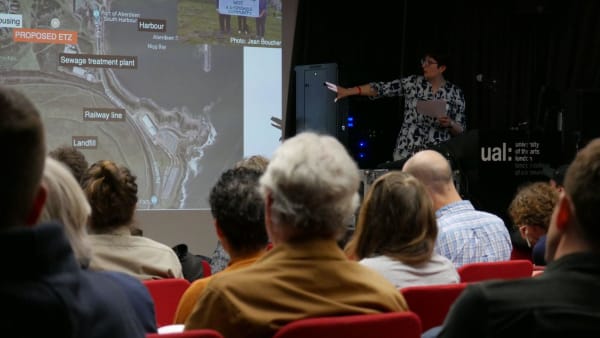 A presenter at UAL explains an image.