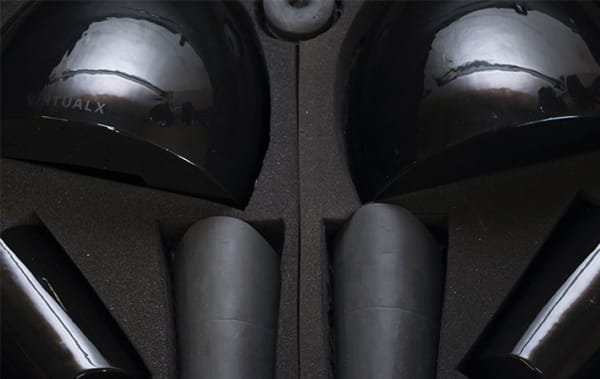 An open box which has a set of black plastic objects inside