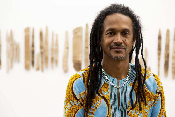 Portrait of Kimathi Donkor in front of work at the Wimbledon College of Arts postgraduate Summer Show 2018