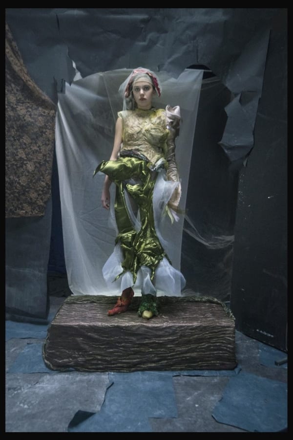 Women wearing green outfit, standing on pedestal