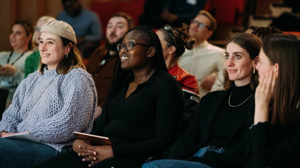 A group of girls sitting in a lecture theatre.