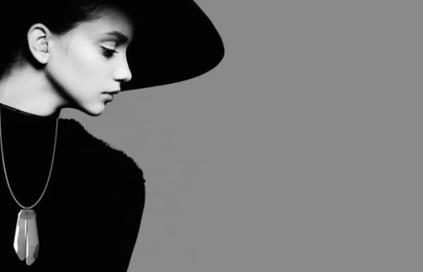 A woman wearing a black hat looking down 