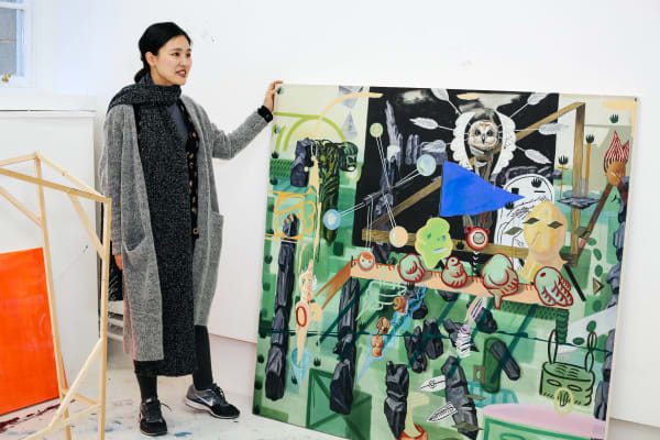 Student looking at a large canvas of their artwork