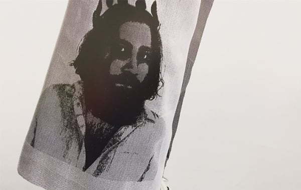Black and white image of a man with a thick beard which has been printed onto a grey material