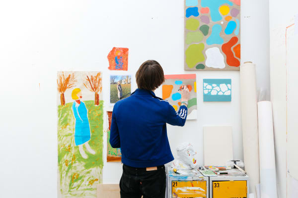 Man standing painting a canvas