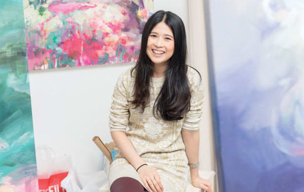 Photo of a woman sitting against a colourful background