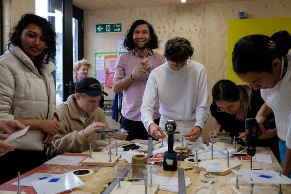 People around table looking through lenses