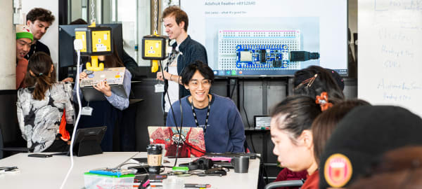 Students working in the studio surrounded by computing equipment