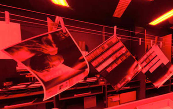 A line of photographs hanging in a dark room