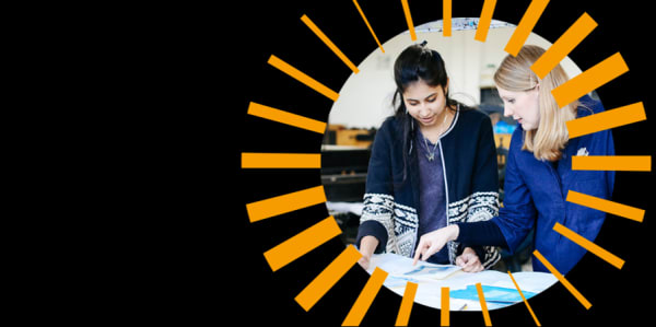 2 people working on print project inside an orange graphic dial circle on a black background.