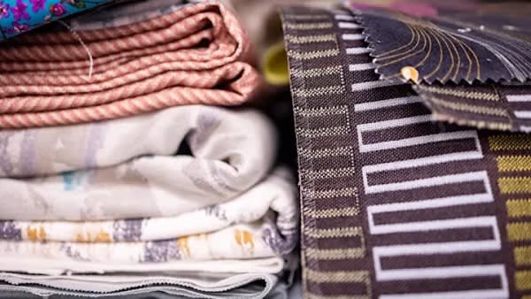 Pieces of colourful patterned fabric stacked next to each other.