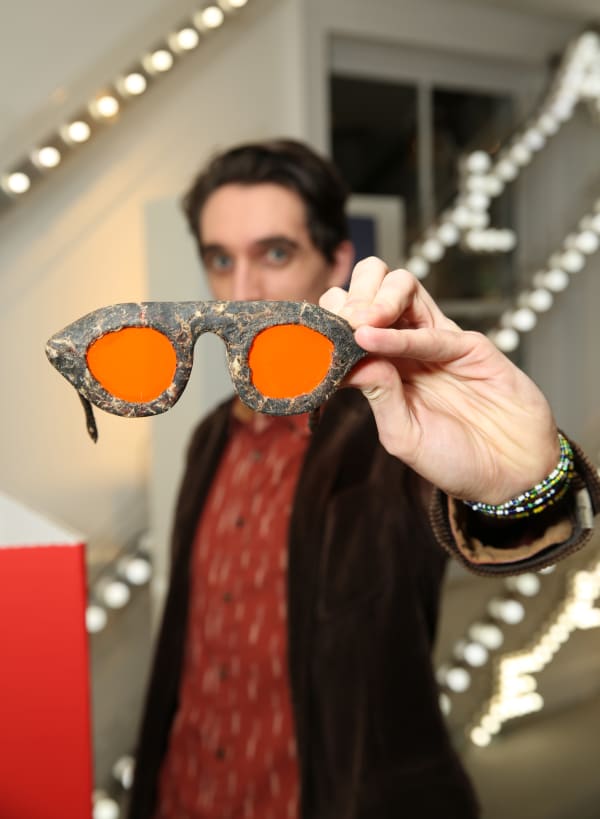 A man holds up a pair of regenerative glasses to the camera