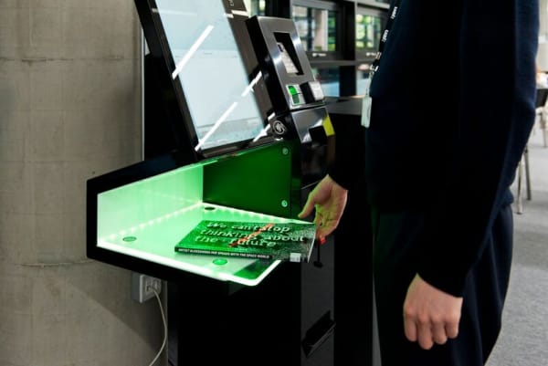 Student scanning a book on a borrowing machine
