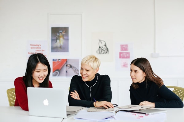 Three women sat at a table talking. BA (Hons) Creative Direction for Fashion, Lottie Laversuch and Sooyeon Kim with Kelly Dearsley (Program Director Fashion Communication), Copyright holder: Alys Tomlinson