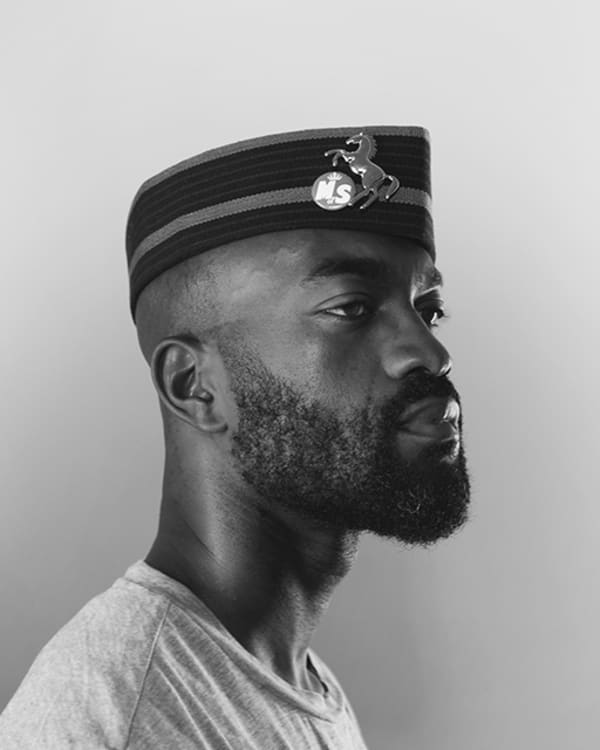 Black and white side profile portrait of Inua Ellams