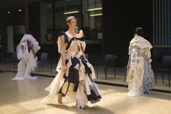 Catwalk with 3 models displaying student garments.