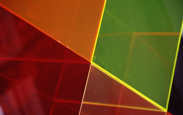 An abstract image of red and green shapes cut with thin, straight yellow lines