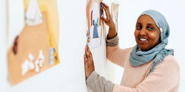 Student with art work on wall