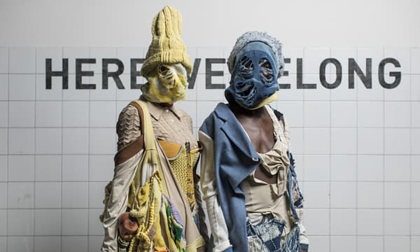 Model wearing sustainable knitwear covering face