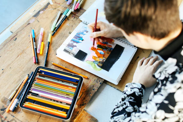 Student drawing with pencils