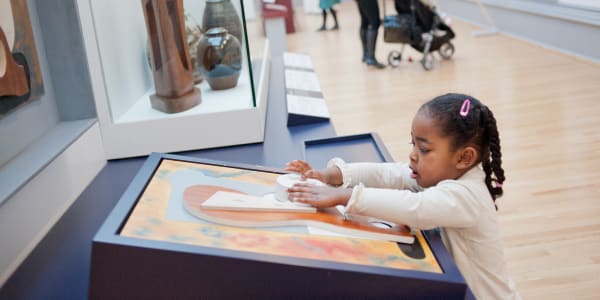 Small girl interacting with artwork in a gallery