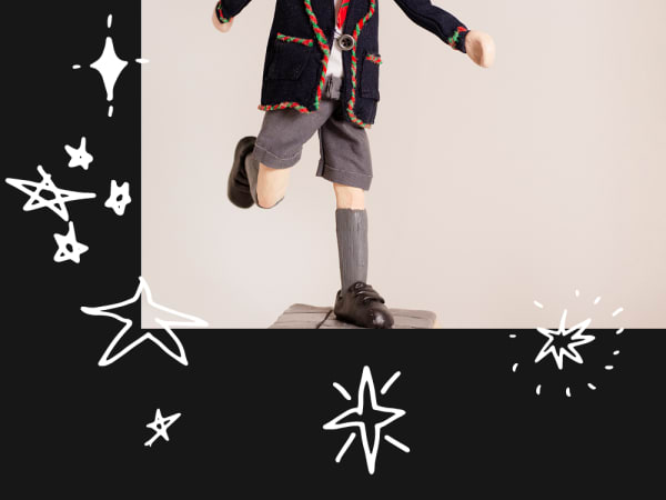 cropped photo of a person in an embroided blazer balancing with one leg on a box