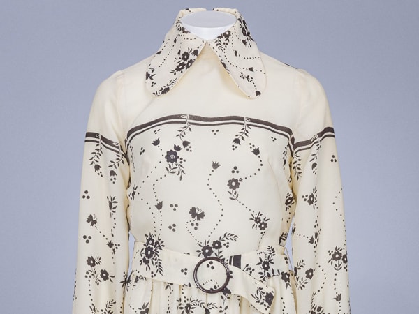 Close-up of vintage cream dress on mannequin.